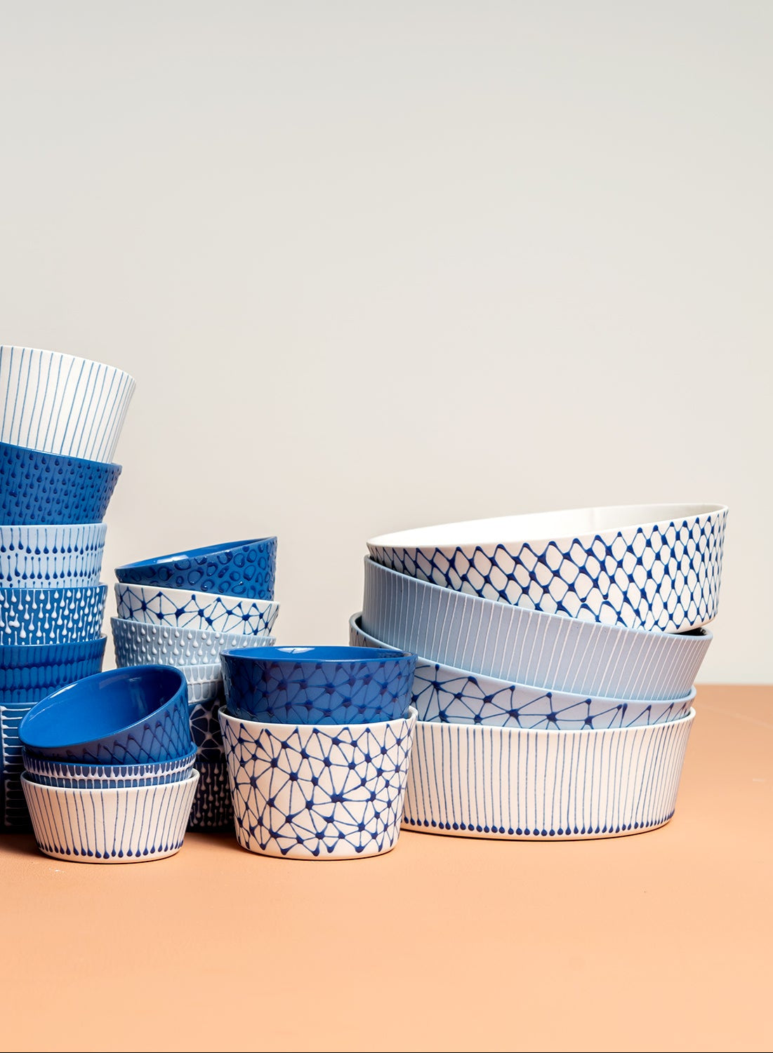Set of blue and white patterned bowls on a beige background